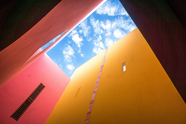 Gelbe und rote Hauswand mit Blick in den blauen Himmelals Beispiel für Triadische Farben